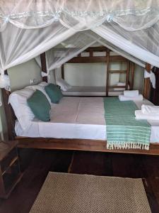 a large bed with a canopy in a room at Villa ecolodge sur l ile de nosy komba in Nosy Komba