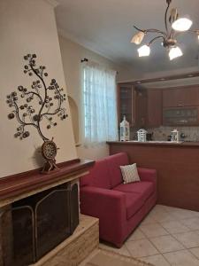 a living room with a red couch and a fireplace at Dimitris Guesthouse in Kapótidhes +12 photos