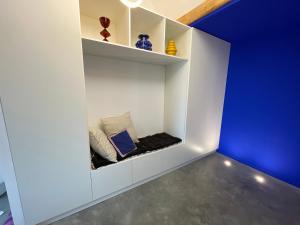 una stanza con scaffali bianchi e una parete blu di Appartement moderne dominant la ville a Pontarlier