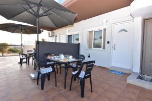 Un patio con una mesa y sillas y una sombrilla. en Iakovos apartments, en Chorafakia