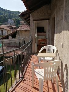 Un patio con dos sillas y una mesa en un balcón. en Casa CINZIA, en Bellagio
