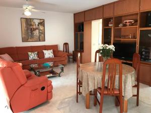 a living room with a red couch and a table at Residencial San Francisco in L'Eucaliptus