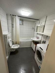 a bathroom with a toilet and a sink and a washing machine at Montör und Studentenzimmer Bett Vermietung UG1 in Geislingen an der Steige +10 photos