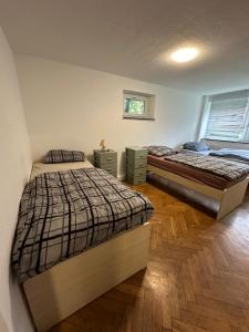 two beds in a room with wooden floors at Montör und Studentenzimmer Bett Vermietung UG1 in Geislingen an der Steige