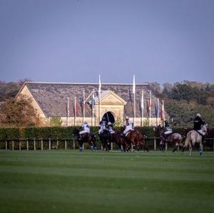 a group of people riding horses on a field at le cottage in Apremont