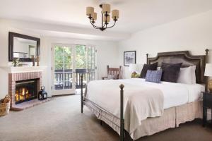 a bedroom with a bed and a fireplace at The Ballard Inn, A Kirkwood Collection Hotel in Ballard