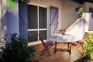 a table and a chair in a room with windows at Les Laurier rose in Saintes-Maries-de-la-Mer