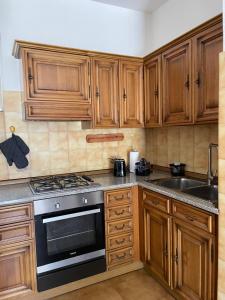 a kitchen with wooden cabinets and a stove and a sink at Cà Maria Maurela in Ossuccio +27 photos