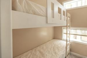 a bedroom with bunk beds and a window at Sun Outdoors Rehoboth Bay in Millsboro