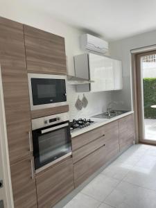 eine Küche mit einem Herd und einem TV an der Wand in der Unterkunft Luxury villa Blue&Blanc piscina a sfioro isola in Diamante