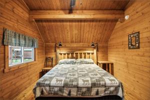 a bedroom with a bed in a log cabin at Lost Horse Lodge King Cabin 12 in Darby