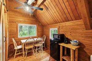 a dining room with a table and chairs in a log cabin at Lost Horse Lodge Double Queen Cabin 19 - PetsOK in Darby