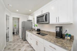 a kitchen with white cabinets and a stainless steel refrigerator at Sun Outdoors Rehoboth Bay in Millsboro +5 photos