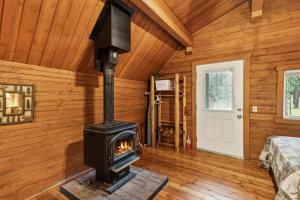 a woodburning stove in a room in a log cabin at Lost Horse Lodge Double Queen Cabin 15 in Darby