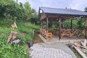 a wooden gazebo with a table and a bench at Deniz ve Doğa Manzaralı Daire Arsin-Trabzon in Arsin
