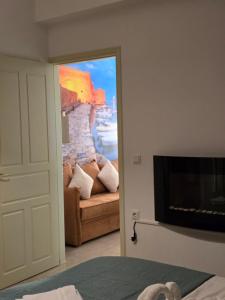 un salon avec un canapé et une télévision dans l'établissement XdreamPort, à Chersónissos