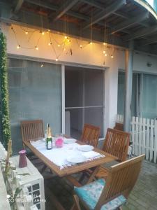 Ein Holztisch und Stühle auf einer Terrasse mit Beleuchtung in der Unterkunft Studioul vacanțelor din Saturn in Saturn