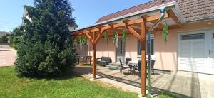 pergola na domu ze stołem i krzesłami w obiekcie Klimatizált, medencés, jakuzzis nyaraló a Balatonnál! w mieście Kőröshegy