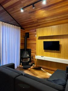 ein Wohnzimmer mit Couch und Kamin in der Unterkunft Cabana Ohana, Espaçosa, Aconchegante e Completa in Urubici + 15 Fotos