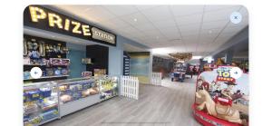 Una tienda con un cartel de precios y una pizzería. en Robinson retreats beautiful caravan with sea views pet friendly, en Mainsriddle