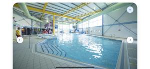 Una gran piscina con agua en un edificio. en Robinson retreats beautiful caravan with sea views pet friendly, en Mainsriddle
