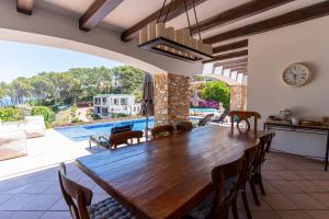 a dining room with a large wooden table and chairs at La Isla in Sa-Riera