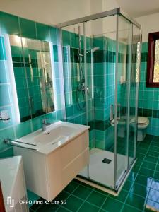 ein Badezimmer mit Waschbecken und Glasdusche in der Unterkunft La Terrazza sul Mare in San Teodoro + 21 Fotos