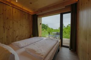 OposhnyaにあるOBRIY holiday villageのベッドと大きな窓のある寝室