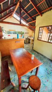 a wooden table and a chair in a room at Camping - Ecohospedagem Canto da da Coruja - traga seu equipamento de camping in Sao Jorge