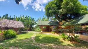 a house with a green roof and a yard at Camping - Ecohospedagem Canto da da Coruja - traga seu equipamento de camping in Sao Jorge