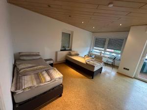 a bedroom with two beds and a chair in it at Monteuren und Studentenwohnungen Bettvermietung in Geislingen an der Steige