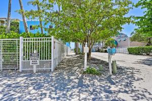 una cerca blanca con un árbol y un parquímetro en Coastal Surfside By Beachside Management, en Siesta Key