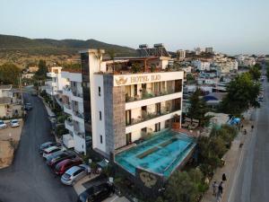 a building with a swimming pool next to a street at Ilio Boutique Hotel in Ksamil