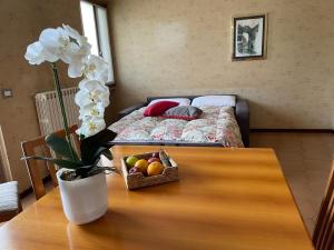a table with a vase of flowers and a bed at Cà Maria Maurela in Ossuccio