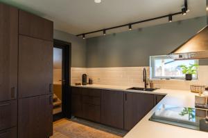 een keuken met bruine kasten en een spoelbak bij Oceanfront Cabin in Lyngedal