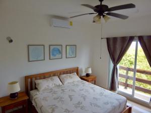 a bedroom with a bed with a ceiling fan at 2 BR-house in Puerto Morelos with stunning view in Puerto Morelos +41 photos