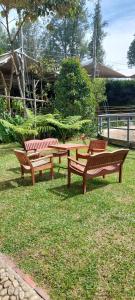 ラ・セハにあるHotel Campestre Ronda Ecuestre Rionegroの公園の芝生に置かれた3つの木製のベンチ