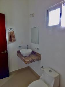 a white bathroom with a sink and a toilet at 2 BR-house in Puerto Morelos with stunning view in Puerto Morelos