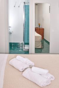 two towels are sitting on a bed in a bathroom at Hotel Victoria Place in Anacapri