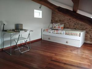 a small bedroom with a bed and a desk at La casa del valle in Viveiro