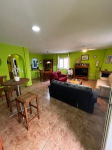 a living room with green walls and a couch and a table at Casa familiar en la almadraba con espectacular terraza in El Pozo del Cabo