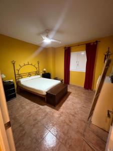 a bedroom with a bed in a room with yellow walls at Casa familiar en la almadraba con espectacular terraza in El Pozo del Cabo