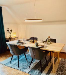 a dining room table with chairs and a table and a light fixture at Charmante Stadtwohnung mit Blick ins Grüne in Lübeck