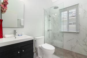Un baño con inodoro y ducha de cristal. en Draxhall Beach Access Gated Community Full Air Con, en Georgia