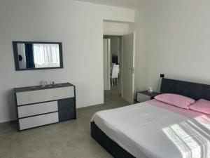 a bedroom with a bed and a dresser with pink pillows at Il Boschetto in Torgiano