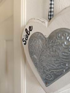a metal heart on a door with the word peace at B&B Casa del Bosco in San Michele al Tagliamento