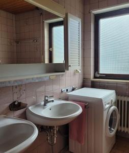 a bathroom with a sink and a washing machine at Haus Thea bei Stuttgart in Leonberg +23 photos