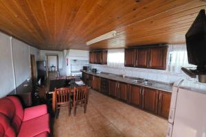 a kitchen with wooden cabinets and a table and chairs at Casa da Avó Clotilde in São Roque do Pico