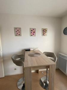 a room with a wooden table and two chairs at Joli appartement proche gare in Molsheim +3 photos