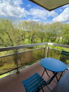 a balcony with a blue table and two chairs at Joli appartement proche gare in Molsheim